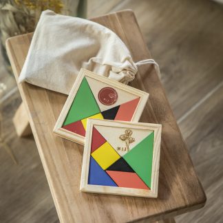 Jogo de puzzle tangram com 7 peças em madeira colorida. A personalização é feita com etiqueta em vinil ou gravação a laser.