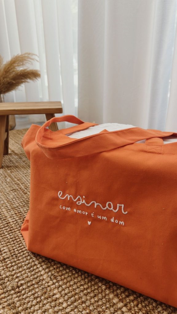 Go Bag laranja personalizado a bordado com a frase "Ensinar com amor é um dom"